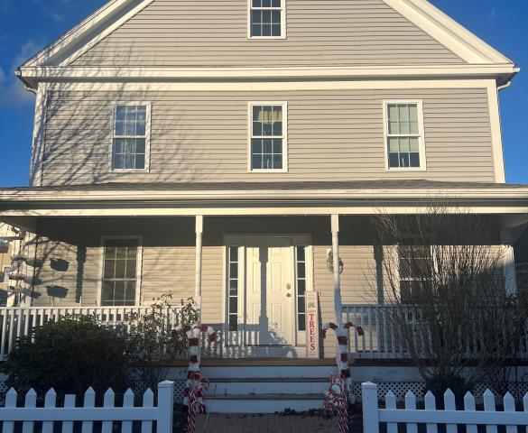 front view of 2-story home with walkway and white picket fence
